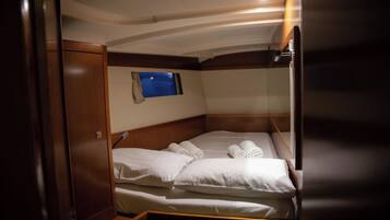 A compact cabin with a bunk bed, a small window, and a view of the night sky.