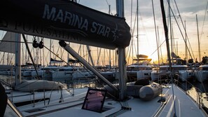 A marina with boats docked, a sign reading 'MARINA STAR,' and a sunset in the background.