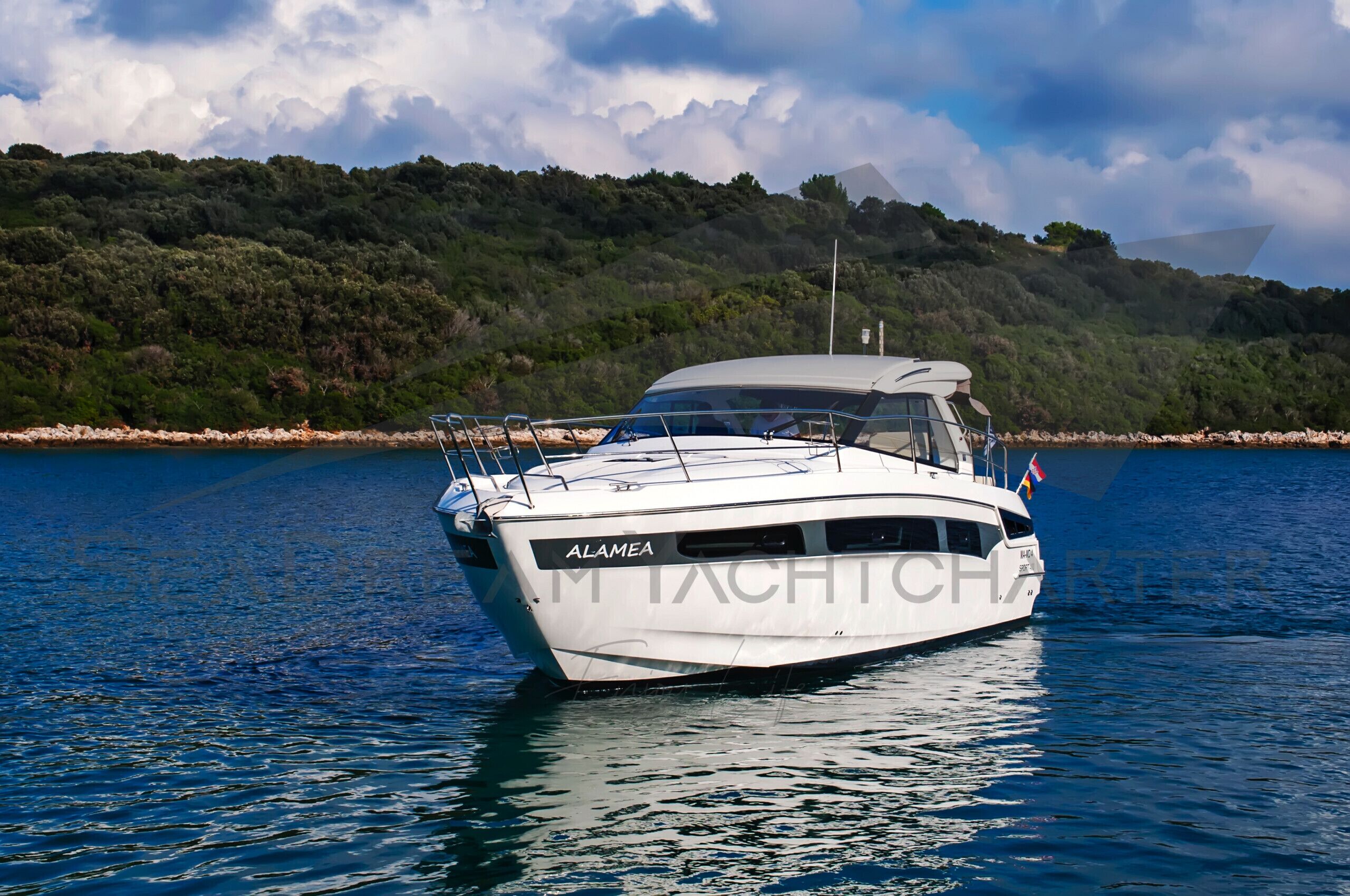 A boat named 'ALAMEA' on calm water with a forested hillside in the background.