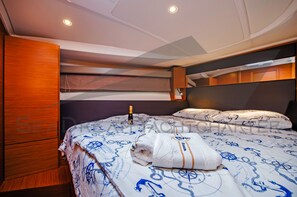 A bedroom with a bed, a wooden wardrobe, and a headboard.