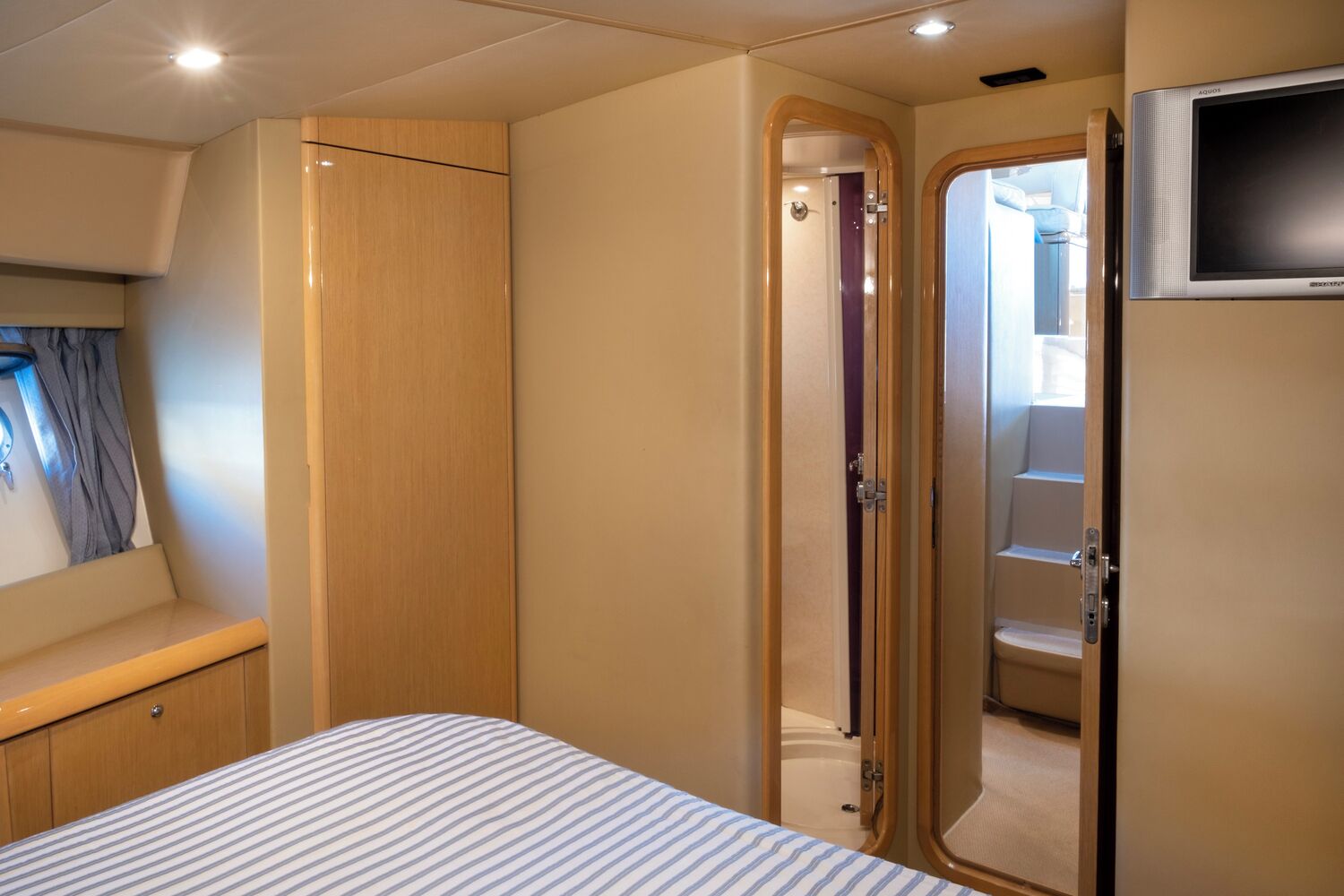 Un dormitorio con cama, armario, ducha y televisión.