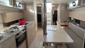 Een kleine keuken met een fornuis, oven en een tafeltje.