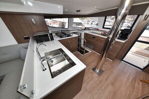Eine moderne Küche mit Edelstahlgeräten, Holzschränken und Blick auf den Yachthafen.