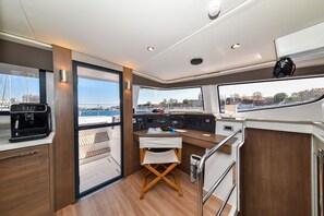 A compact galley with a coffee machine, a foldable table, and a view of the water. - Sun-Kissed Sailing Adventure in Zadar, Croatia (Zadar)