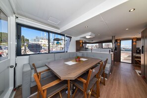 A modern interior with a dining area, large windows, and a view of the marina. - Sun-Kissed Sailing Adventure in Zadar, Croatia (Zadar)