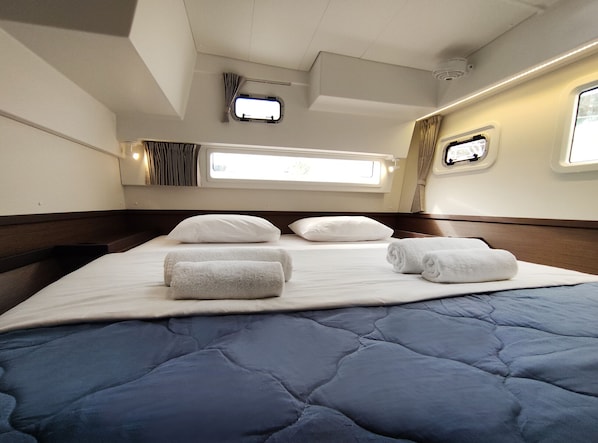 Una habitación de hotel con cama, almohadas y toallas enrolladas.