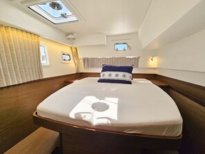 Eine Hütte mit einem Bett, einem Oberlicht, einem kleinen Fenster und einer Wandleuchte.