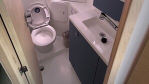 A compact bathroom with a toilet, sink, and mirror. - Sun-Kissed Sailing Adventure in Zadar, Croatia (Bibinje)