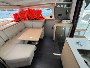 A compact galley with a wooden table, a sink, and a compact refrigerator. - Sun-Kissed Sailing Adventure in Zadar, Croatia (Bibinje)