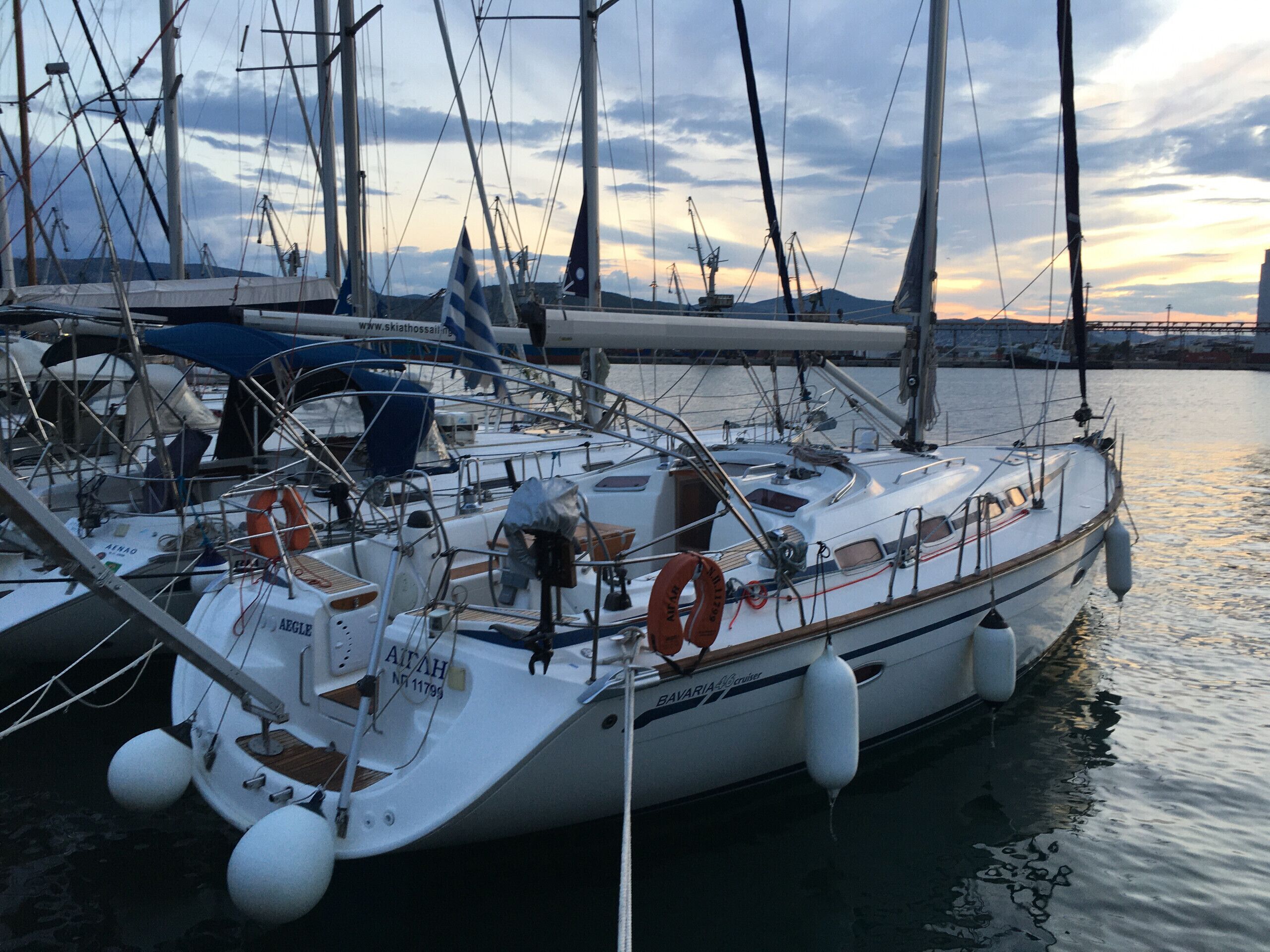 Ein Yachthafen mit mehreren Segelbooten, die an den Kai liegen, mit Masten, Segeln und Rettungsringen.
