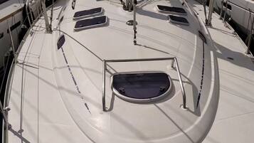 The deck of a sailboat with multiple windows and a central mast.