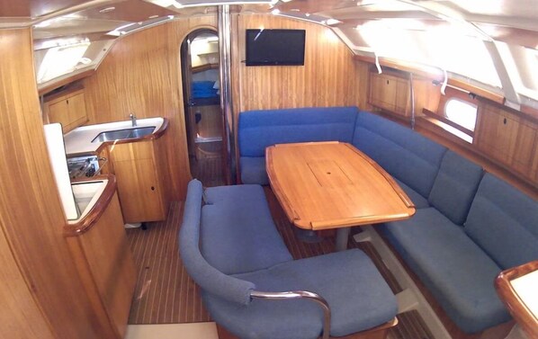 A compact interior with a kitchenette, a dining table, and seating.