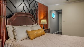 A bed with a headboard, pillows, and a bedside table with a lamp. - Casa de Valdes: Spacious Two-Story Home Near SeaWorld and Military Bases (San Antonio)