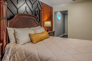A bed with a headboard, pillows, and a bedside table with a lamp. - Casa de Valdes: Spacious Two-Story Home Near SeaWorld and Military Bases (San Antonio)