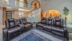 A spacious living area with a high ceiling, a staircase, and a dining area. - Casa de Valdes: Spacious Two-Story Home Near SeaWorld and Military Bases (San Antonio)