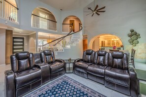 A spacious living area with a high ceiling, a staircase, and a dining area. - Casa de Valdes: Spacious Two-Story Home Near SeaWorld and Military Bases (San Antonio)