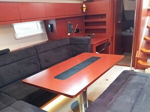 A compact living space with a sofa, a table, and a small kitchenette area. - Sun-kissed Sailing Adventure in the Ionian Islands (Preveza)