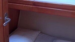 Ein Etagenbett mit weißer Bettwäsche und einem Holz-Kopfteil.