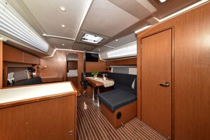 A compact interior with a dining area, a seating area, and a door. - Sun-Kissed Sailing Adventure in Zadar, Croatia (Bibinje)