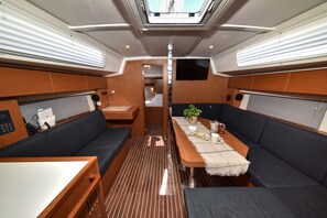 A compact interior with a dining area, seating, and a small kitchenette. - Sun-Kissed Sailing Adventure in Zadar, Croatia (Bibinje)