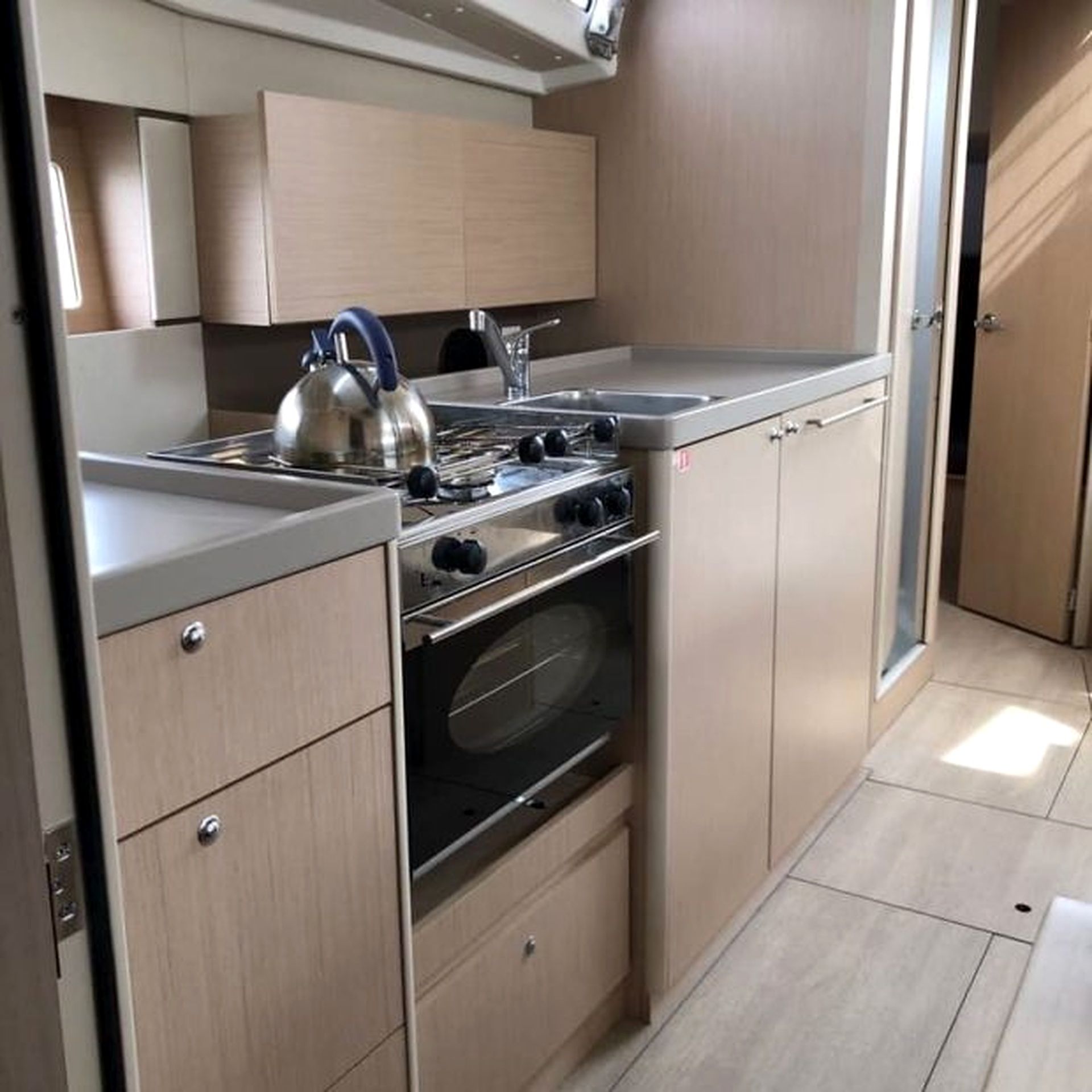 Une cuisine compacte équipée d’une cuisinière, d’un four et d’une bouilloire.