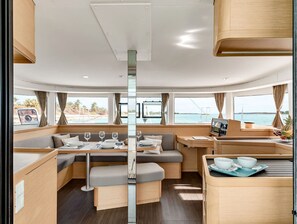 Un interior moderno con una zona de comedor central, asientos y un panel de control.