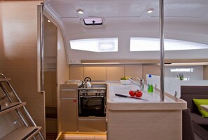 Une cuisine de taille réduite, équipée d’une cuisinière, d’un évier et d’un petit plan de travail.