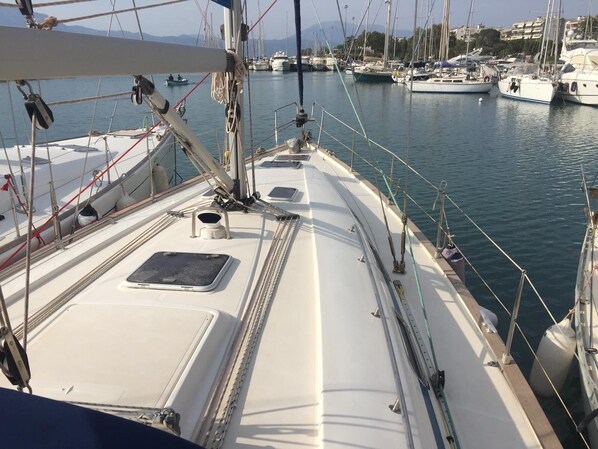 Marina con barcos amarrados, cielo despejado y mar en calma.