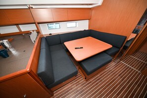 Espaço compacto com sofá, mesa pequena e janela.
