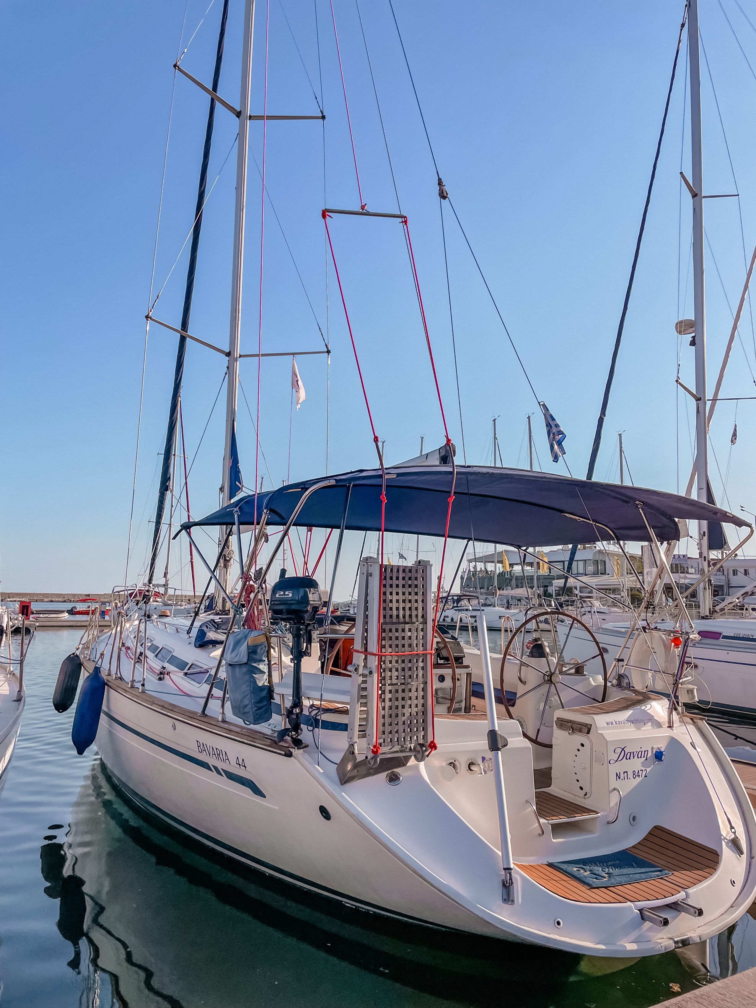 A sailboat docked at a marina with a clear sky.