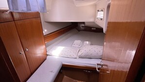 Une cabine compacte comprenant un lit superposé, un petit coin salon et une armoire.