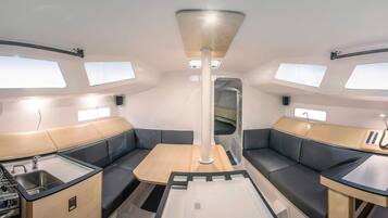 Un intérieur moderne et compact comprenant un coin cuisine, un espace salon et un éclairage au plafond.