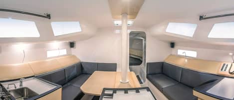 Un intérieur moderne et compact comprenant un coin cuisine, un espace salon et un éclairage au plafond.