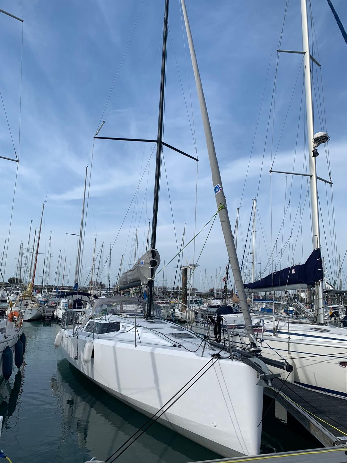 A marina with multiple sailboats docked.
