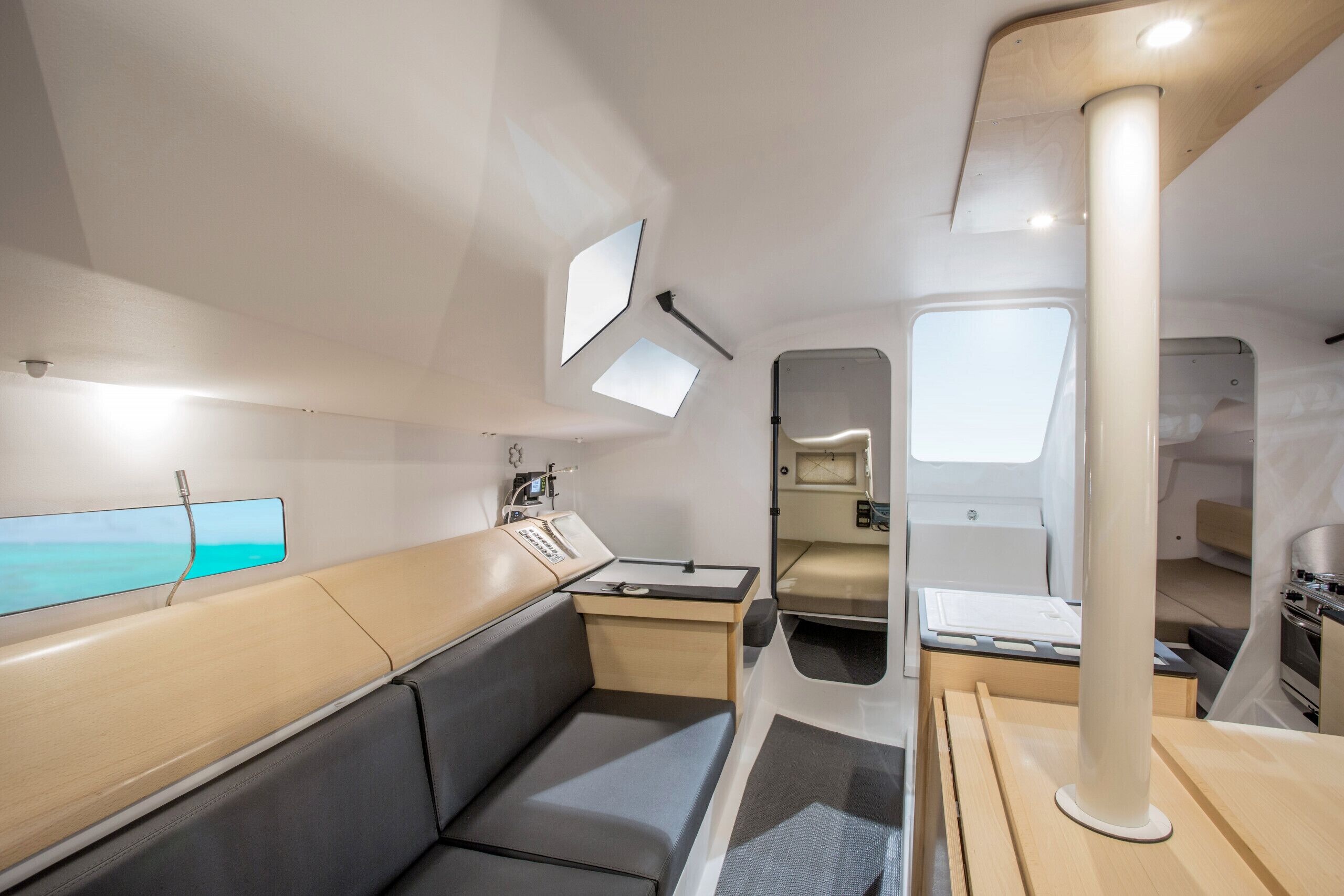 Un intérieur moderne comprenant un coin salon, une petite kitchenette et une fenêtre offrant une vue.