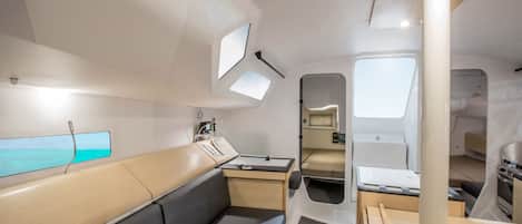 A compact, modern interior with a seating area, a small table, and a window providing a view.