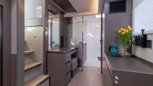 Un baño moderno y funcional con ducha, inodoro y tocador.