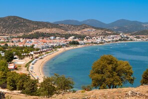 A coastal town with a beach, clear blue sea, and mountains in the background. - Sun-Kissed Sailing Adventure in the Saronic Islands (Nea Peramos)