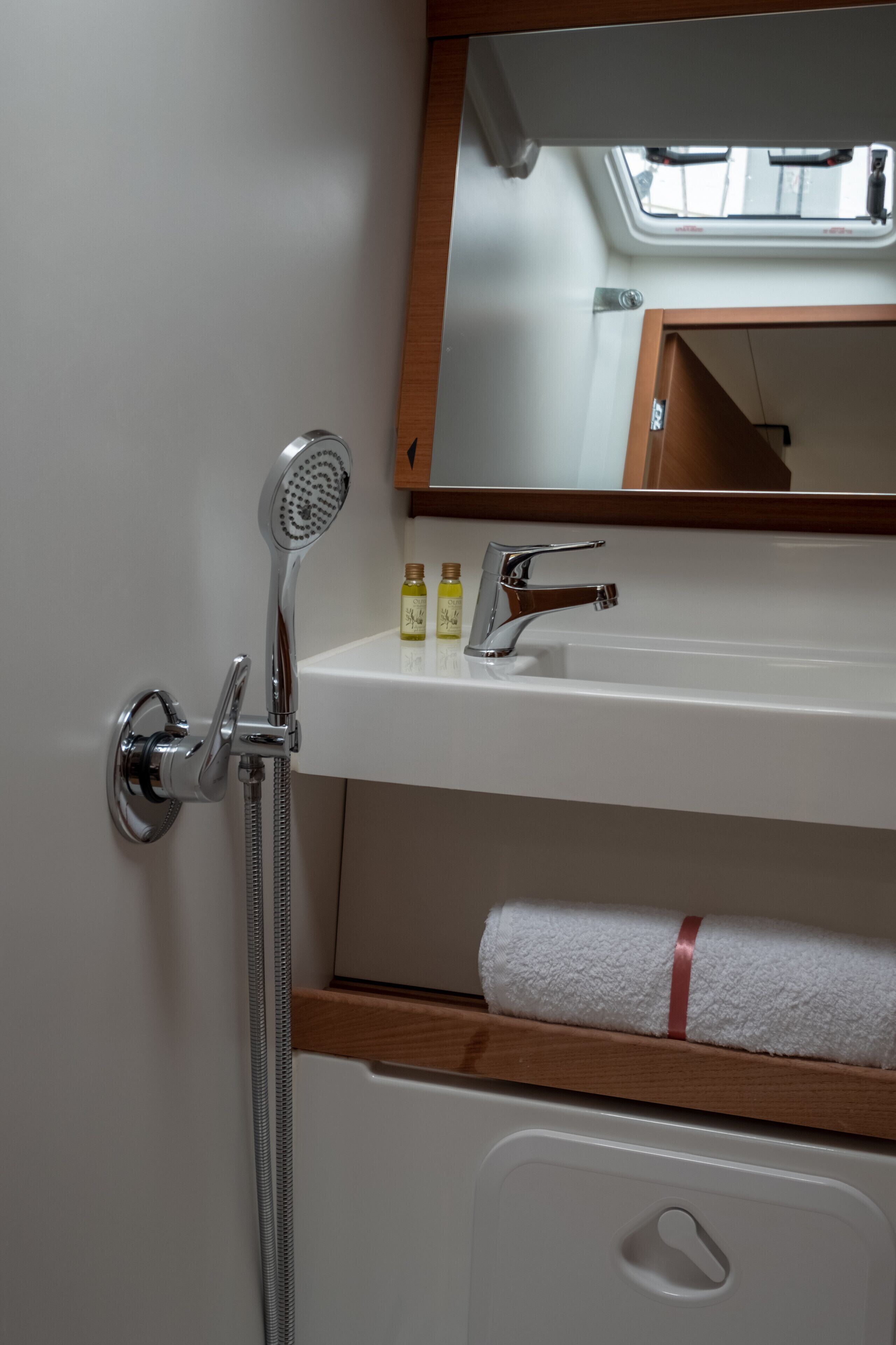 Ein Badezimmer mit Dusche, Waschbecken, Spiegel und Handtuchhalter.