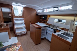 A compact galley with a stove, sink, and storage cabinets. - Sun-Kissed Sailing Adventure in the Ionian Islands, Lefkada (Lefkada)