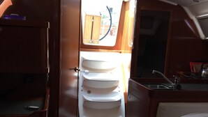 A compact cabin with a bed, a small kitchenette, and a window with a view of the outside. - Sun-Kissed Sailing Adventure in the Ionian Islands, Lefkada (Lefkada)