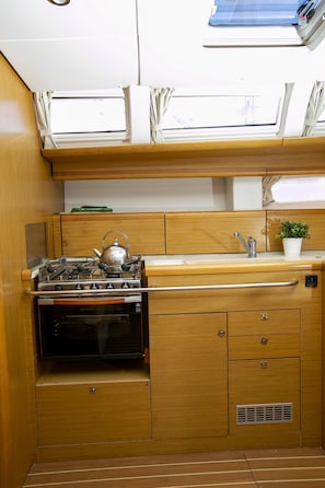 A compact kitchen with a stove, oven, and a small sink.