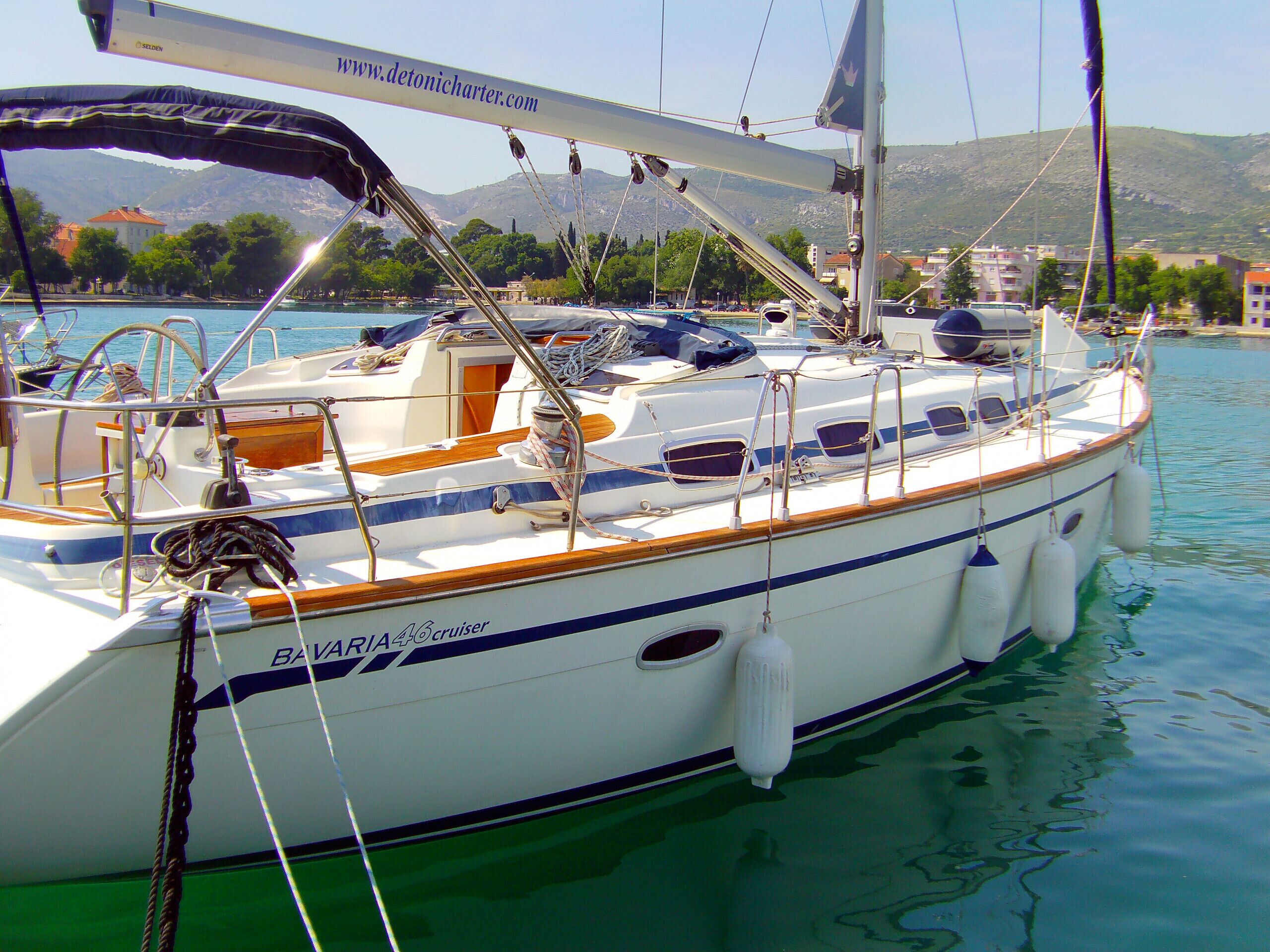 A sailboat with a cabin, deck seating, and a mast.
