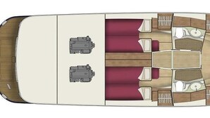 A boat interior with a central dining table, two sofas, and a small kitchen area. - Sun-Kissed Sailing Adventure in Zadar, Croatia (Bibinje)