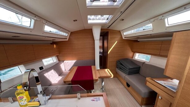 Een compact interieur met een eethoek, een zithoek en een kleine kitchenette.