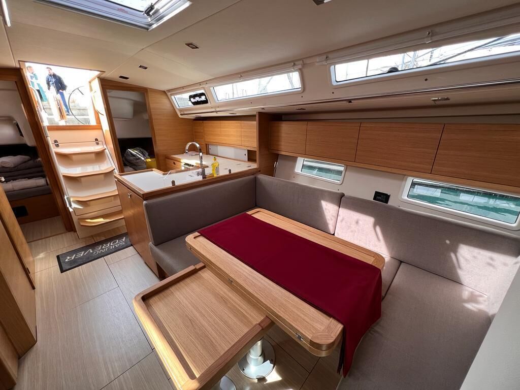 A compact, well-lit interior with a kitchenette, seating area, and windows.