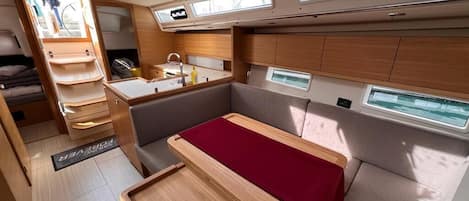 A compact, well-lit interior with a kitchenette, seating area, and windows.