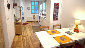 A compact kitchen with a dining area, wooden flooring, and a view into the living space. - Charming house in the historic district with a garage (Foix)