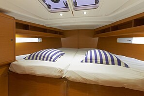 A cabin with two beds, a skylight, and wooden paneling. - Sun-Kissed Sailing Adventure in the Serene Saronic Islands (Elefsina)