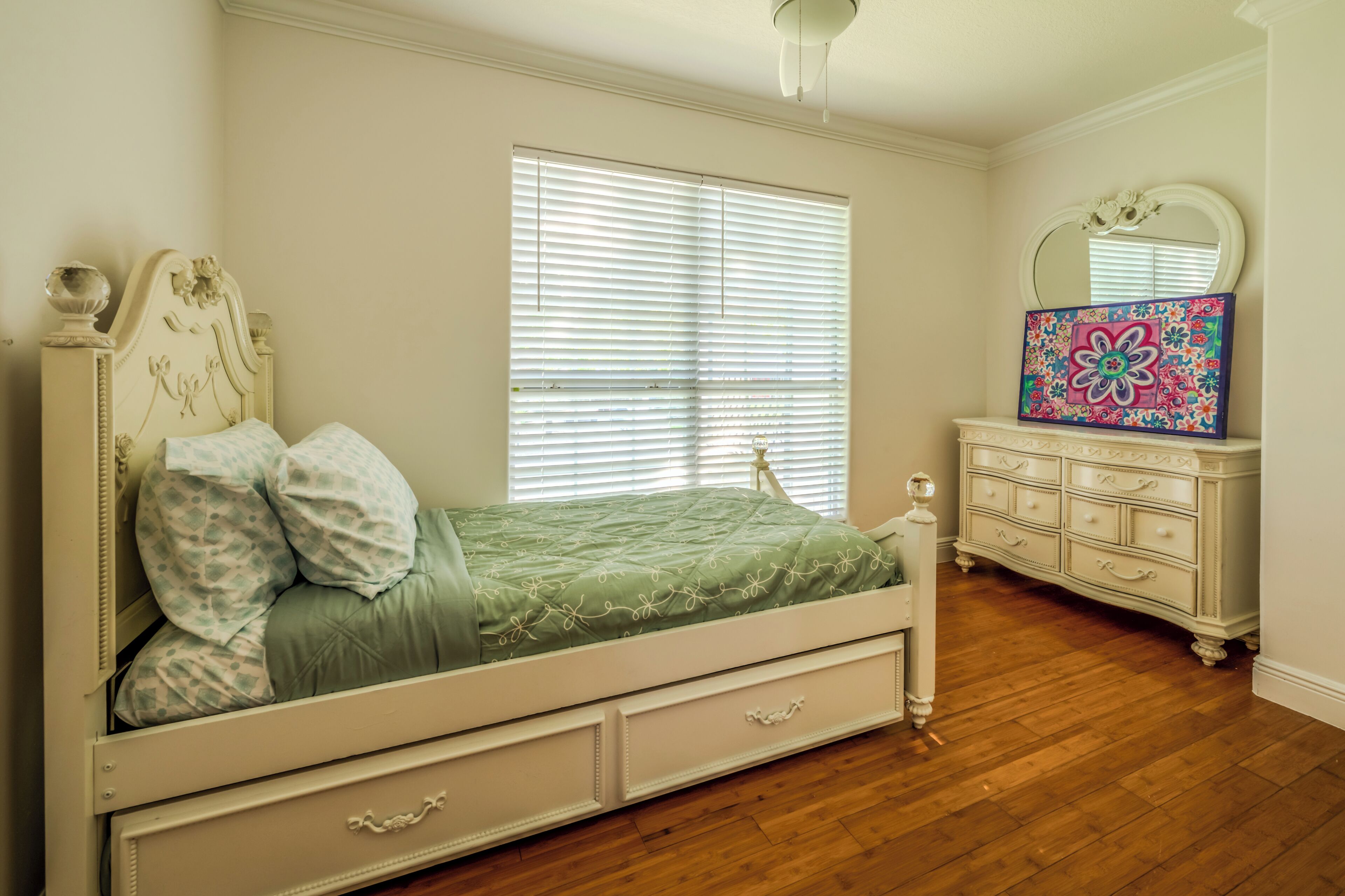Un dormitorio con cama, cómoda y espejo.